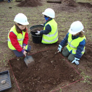 Primary school children helping to excavate test pits. © Copyright ARS Ltd 2018