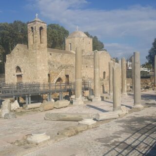 Photo of the remains of the basilica in the foreground and the medieval church of Ayia Kyriaki in the background