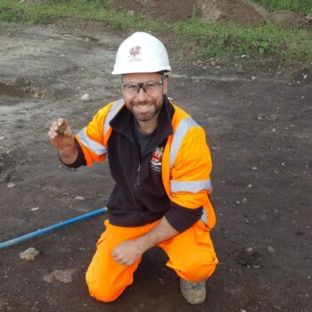 One of our team holding a coin discovered on the edge of the wetland.