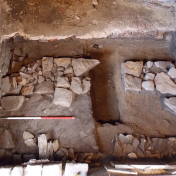 The substantial wall foundations of the previous building found within Trench 2 (scale = 1m). © Copyright ARS Ltd 2021