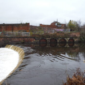 The weir built in 1793 and remains of the structure that housed the water wheels which initially powered the industrial complex © Copyright ARS Ltd 2022