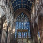 In this week’s #BuildingKnowledge we are back looking at the magnificent Carlisle Cathedral, focusing upon the triumphant eastern window and the phasing of the Cathedral’s choir. The choir is over seven bays with ranges of 13th century Gothic arches on clustered columns, with the decorated Gothic arched eastern window installed c.1350. The window is over 50 feet tall, and had been designed by Ivo de Raghton, with a range of surviving original stained glass. The in-situ choir space had superseded a shorter and narrower choir, which had been rebuilt following a fire in the Cathedral in 1292. The phasing of the earlier choir is evident from the western end, which features a Gothic archway for the organ, with this representing the earlier width of the choir. Adjacent to this, to the right, there is a straight joint and blocked Norman arch associated with an earlier aisle. Within the upper portions of the walling, there are markings to show that there had been plans to rebuild this area with an archway matching the scale of the eastern window, though this had not come to fruition. © ARS Ltd 2022