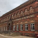 In this week’s #BuildingKnowledge we're looking at the highly decorative Grade II* Listed Former Wedgwood Institute, Burslem, Stoke-on-Trent, which may look more at home as a palazzo within the city of Venice. The building had been constructed in the Venetian Gothic style as a library and art school in 1869 by Nichols of Wolverhampton, and further modified in design by Robert Edgar and John Lockwood Kipling. It had been built in honour of Josiah Wedgwood, who had been a titan of pottery in the 18th century, and had played a huge role in developing the industry within the Potteries towns. The richly decorated red brick building with terracotta dressings features a bust of Wedgwood above the central archway, with 10 carved terracotta panels between the floors depicting the process of manufacturing pottery. At first floor level, there is a continuous arcade with blind Gothic arches supported by engaged columns, which feature terracotta panels depicting months of the year and their zodiac signs. © ARS Ltd 2021