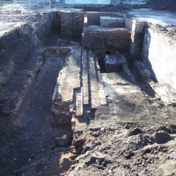 Boiler beds in basement in Area 2 with arched flue and chimney in background © ARS Ltd 2023