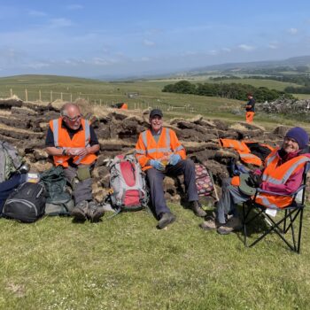 Happy volunteers on site catching some rays and resting after a full morning's work © ARS Ltd 2025